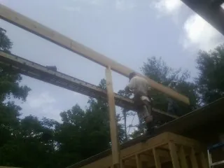 Carpenter setting a ridge beam over a new addition frame — Ice Dam Removal by Roofing Brothers in Overbrook