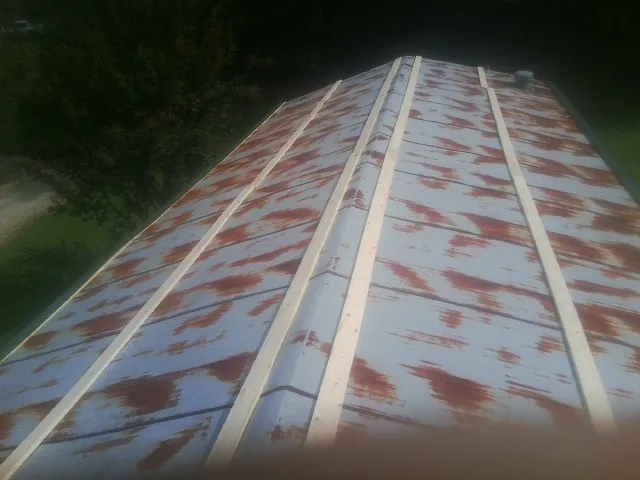 Rusted metal roof panels with new wood purlins before replacement — Storm Damage Roof Repair in Overbrook by Roofing Brothers