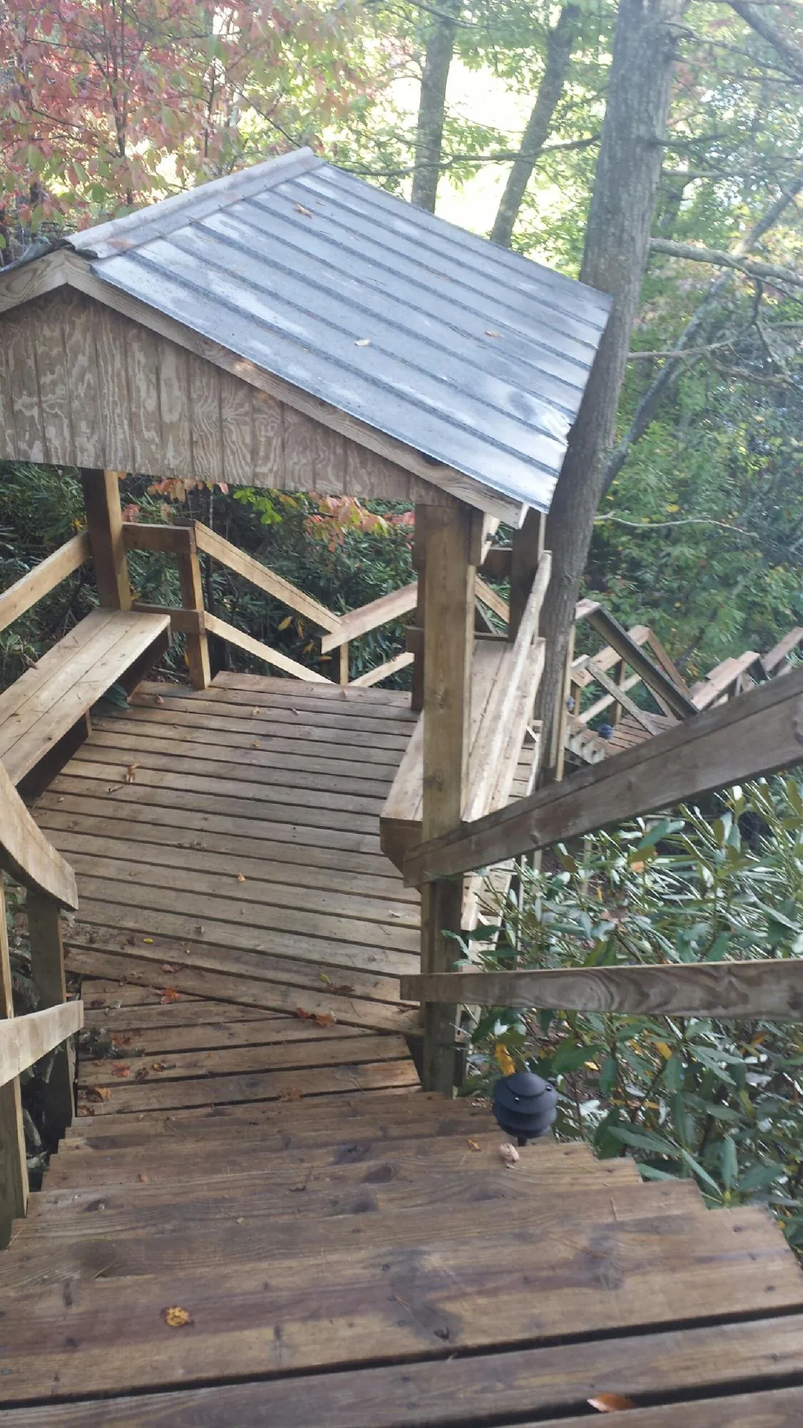 Metal roofed shelter over wooden steps on a wooded walkway — Skylight Repair & Installation work by our crew in Overbrook