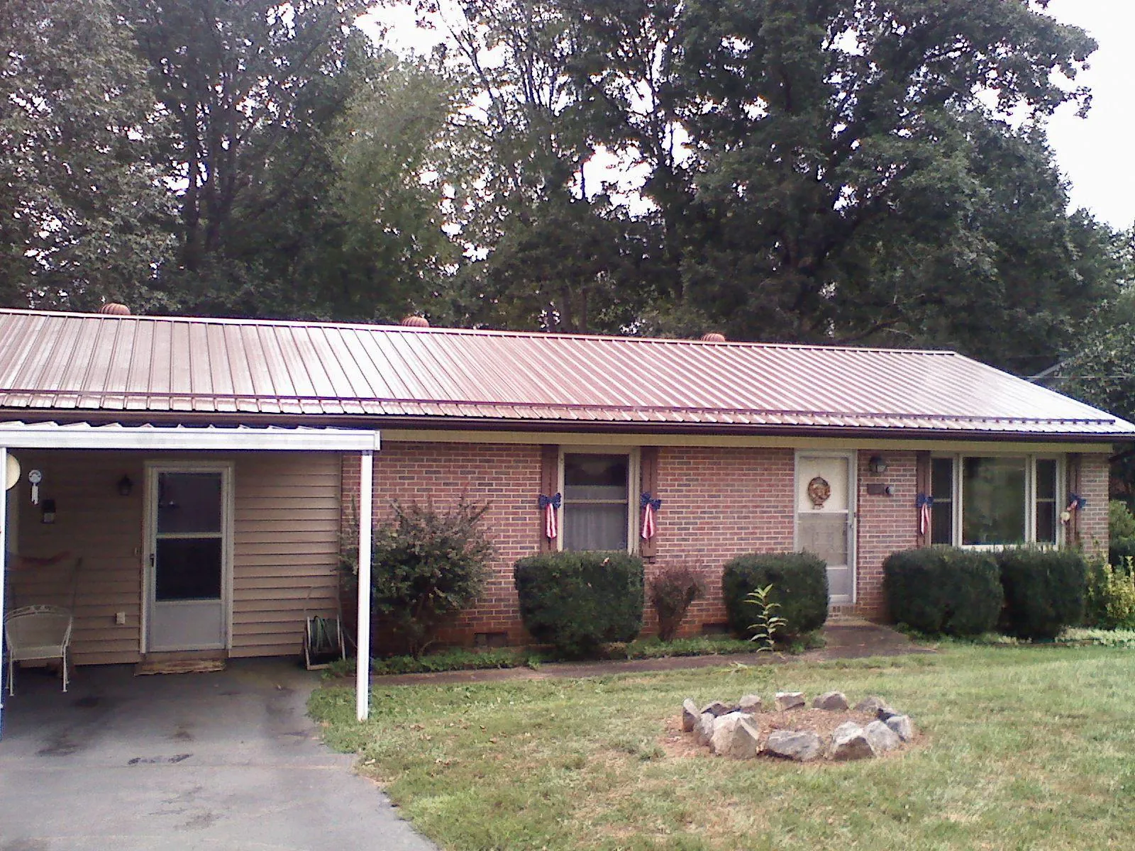 Bronze metal roof and carport on a brick ranch home — Roof Repair work by our crew in Overbrook